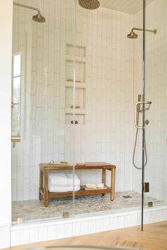 a bathroom with a stand up shower and wooden bench