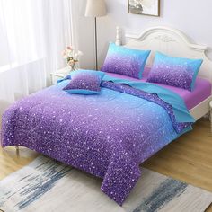 a bed with purple and blue comforters in a bedroom