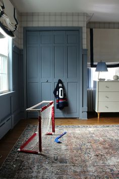 a bedroom with blue walls and an area rug