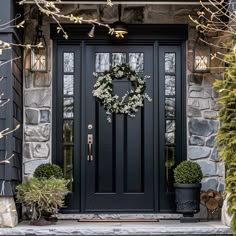 a black front door with a wreath on it