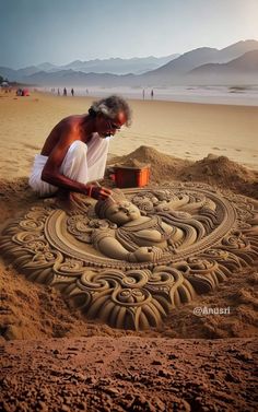 a man sitting on top of a sandy beach next to a sand art design in the sand