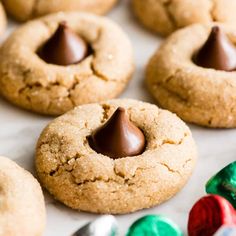 chocolate chip cookies with m & m candy in the middle on a baking sheet, ready to be eaten