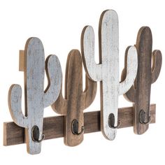 three wooden cactus hooks hang on a wall