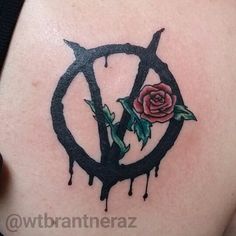 a rose tattoo on the back of a woman's shoulder, with dripping paint