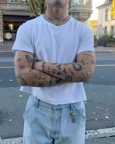 a man with his arms crossed standing on the street