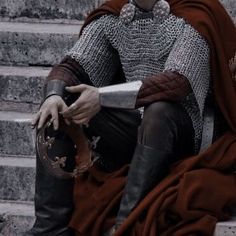 a man dressed as a knight sitting on some steps