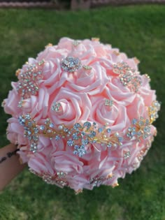 a bridal bouquet in the shape of a rose with jewels on it is being held by someone's hand