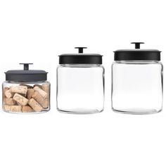 three glass jars with black lids and corks