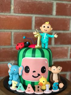 a birthday cake decorated with an image of a child's face and various toys