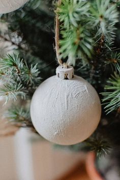 a white ornament hanging from a christmas tree