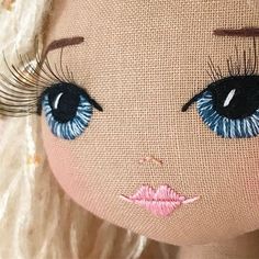 a close up of a doll's face with blue eyes