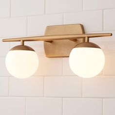 two light fixtures on the wall in a bathroom