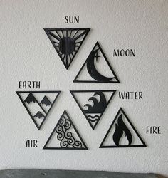 four different types of paper cut shapes on a white wall with the words earth, water, and fire written below them