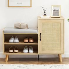 a wooden cabinet with shoes on it next to a white rug