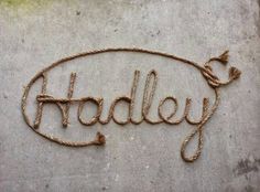 the word radley written in rope is on top of a concrete surface with a knot around it