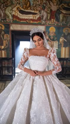 a woman in a white wedding dress with long sleeves