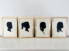 three framed silhouettes of people's heads in black and white on a shelf