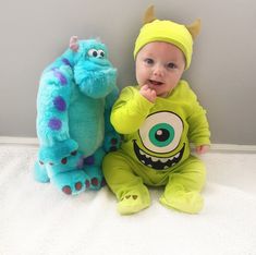 a baby sitting next to a stuffed monster