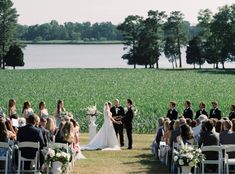 a bride and groom standing at the end of their wedding ceremony in front of a corn field