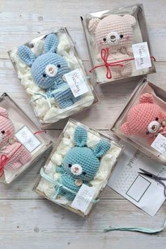 four small crocheted stuffed animals in boxes