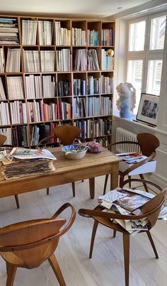 a wooden table sitting in front of a bookshelf filled with lots of books