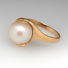 This elegant ring is centered with one (1) fresh water pearl and is set into a gold swirl. The ring is crafted in 14k yellow gold and currently a size 7. Classic 14k Gold Bypass Ring For Formal Occasions, Classic White Bypass Ring For Formal Occasions, Classic Gold Bypass Ring For Formal Occasions, Classic Gold Bypass Ring For Formal Events, Gold Rings With Pearl Drop For Formal Occasions, Elegant Gold Oval Bypass Ring, Elegant 14k Gold Bypass Ring, Timeless Yellow Gold Pearl Ring For Formal Occasions, Timeless Yellow Gold Pearl Ring For Formal Events