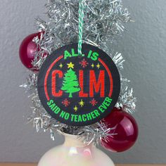 a christmas ornament hanging from the side of a vase with tinsel on it