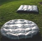 two mattresses sitting in the grass on top of a green field next to each other