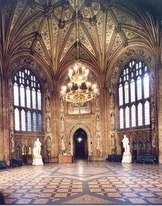 the inside of a building with statues and chandeliers