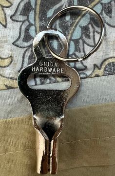 a metal keychain with the words union hardware hanging from it's side