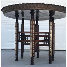 an ornately designed table sits in front of a garage door