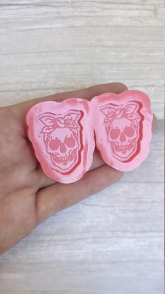 two pink gummy bears shaped like skulls