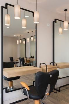 a hair salon with mirrors, chairs and lights