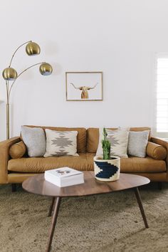 a living room with a couch, coffee table and lamp