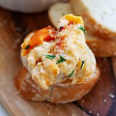 a close up of bread on a cutting board with eggs and cheese in the middle