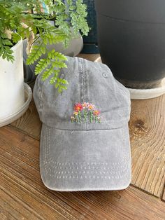 a gray hat sitting on top of a wooden table next to a potted plant