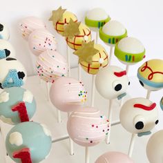 there are many cake pops with different designs on the top one is pink, white and blue