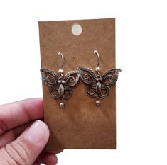 These vintage drop earrings are a must-have for any jewelry collection. The butterfly shape is a classic and timeless design that is sure to catch the eye of anyone who sees them. Made from high-quality 925 china sterling silver, these earrings are durable and long-lasting.  The dangle/drop style adds an elegant touch to any outfit, making them perfect for both casual and formal occasions. The 1.5" length is just right for the average earlobe, and the silver color complements any skin tone. These earrings were made in China and have a rich history that adds to their unique charm. Add them to your collection today and enjoy the beauty and timeless elegance they bring. Silver Butterfly Earrings With Ear Wire, Silver Butterfly Earrings For Gift, Butterfly Shaped Silver Earrings For Gifts, Sterling Silver Butterfly Earrings With Ear Wire, Butterfly Earrings With Ear Wire As Gift, Silver Butterfly Earrings For Formal Occasions, Butterfly-shaped Earrings With Ear Wire As Gift, Vintage Silver Earrings For Gift, Butterfly Earrings With Ear Wire For Gifts