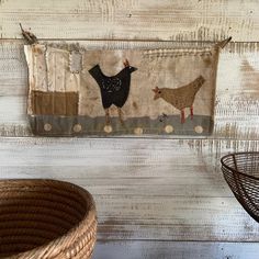 a wall hanging with two chickens on it