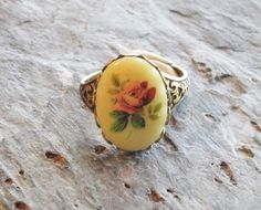 A gorgeous, vintage detailed cameo of a dusty pink rose with a pale yellow background set in detailed antique brass. Ring is antique brass with an adjustable, detailed band. Details: Ring measures approx 25x18mm Ring is plated brass Ring band is adjustable Lead and nickel free Cameo vintage glass Thank you for shopping Delicate Industry :) Vintage Oval Jewelry With Rose Design, Antique Oval Flower Ring Gift, Antique Oval Flower Ring As Gift, Antique Oval Flower Ring As A Gift, Vintage Oval Flower Ring, Vintage Brass Cabochon Rings, Vintage Rose Design Flower Ring For Wedding, Vintage Ring With Rose Design, Vintage Rose Design Rings As Gift