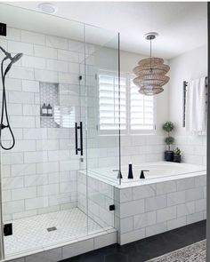 a white tiled bathroom with a walk in shower