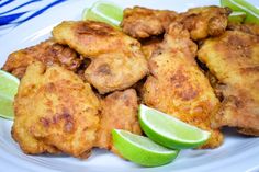 fried chicken with lime wedges on a white plate