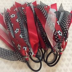 several red and black ribbons are tied to each other on a white surface with hearts in the background