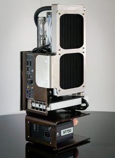 an electronic device sitting on top of a black table next to a white wall in the background