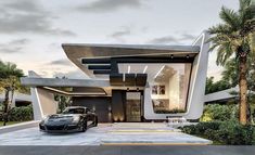 a black sports car parked in front of a modern house with palm trees around it