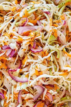 a salad with carrots, onions and shredded cheese