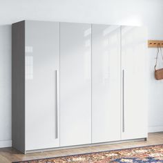 a room with white cabinets and a rug on the floor in front of an area rug