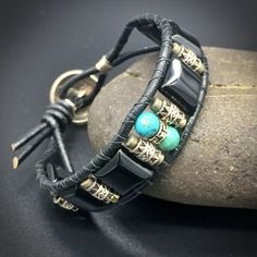 "Mens Turquoise and Onyx beaded leather wrap bracelet in sterling silver with a a dash of Pyrite finished off with a genuine Indian-head Nickel button clasp. Handmade in my home studio in Austin, Texas, U.S.A. I love designing mens jewelry! I always imagine what kind of man will wear it. This bracelet is made of turquoise, onyx, pyrite and sterling silver. The button clasp is made of genuine Indian-head nickel and comes in an Indian Head or Buffalo Head faced The style combines a modern, masculi Adjustable Leather Bracelets With Natural Stones, Leather Bracelets With Natural Stones For Gifts, Artisan Hand Wrapped Black Bracelets, Bohemian Leather Jewelry Hand Wrapped, Artisan Hand Wrapped Black Bracelet, Artisan Hand-wrapped Black Bracelet, Elegant Hand Wrapped Leather Jewelry, Adjustable Masculine Silver Jewelry, Masculine Adjustable Silver Jewelry