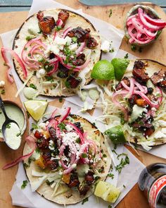 three tacos with toppings are sitting on a cutting board