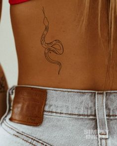 a woman with a snake tattoo on her lower back and the upper part of her stomach